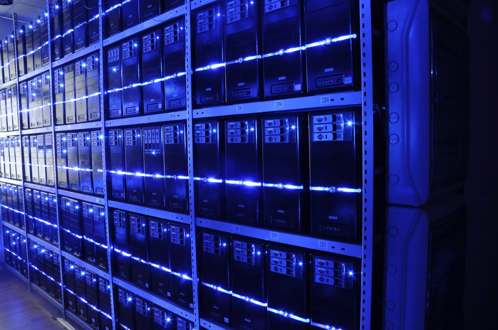 Aisle of server racks in a data center, representing AI compute build-out