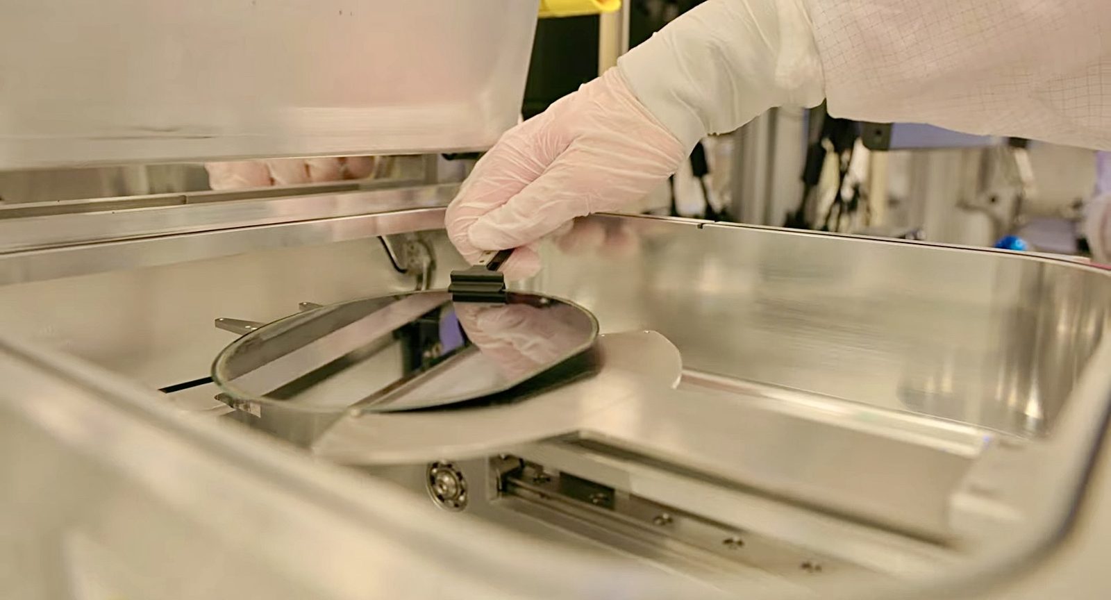 A semiconductor wafer being lifted from processing equipment in a cleanroom